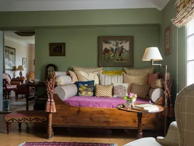 Assorted cushions on antique daybed in in sitting room with kelim upholstered ottoman