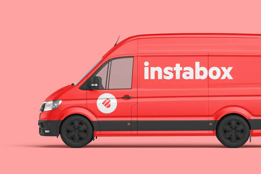 Rød varebil med tekst instabox foran en rosa vegg