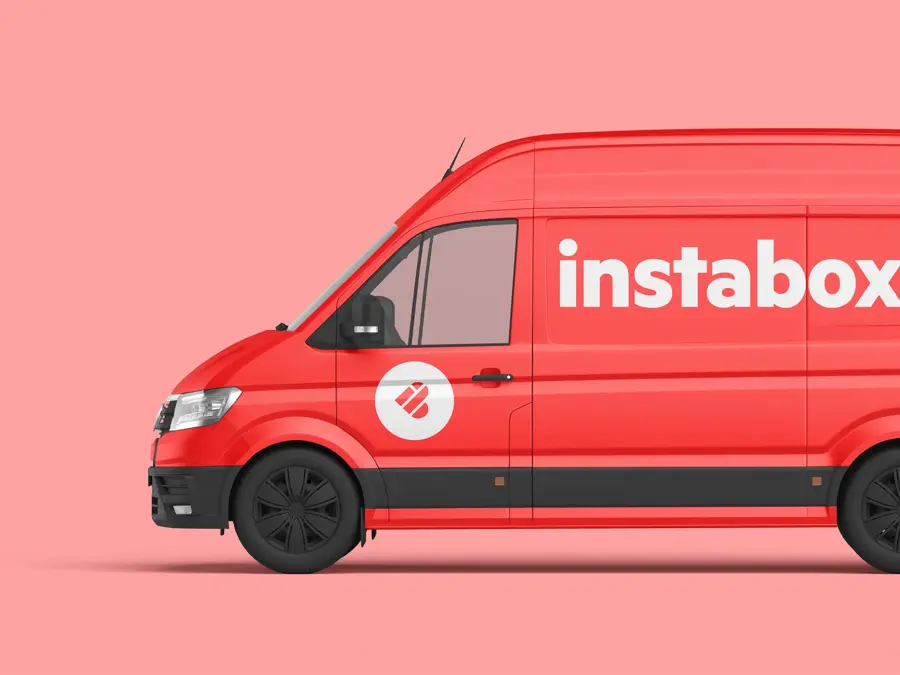 Rød varebil med tekst instabox foran en rosa vegg