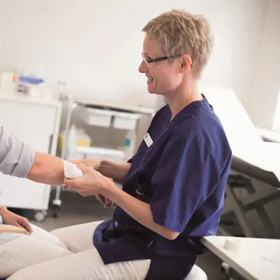 lege som holder i armen til pasient