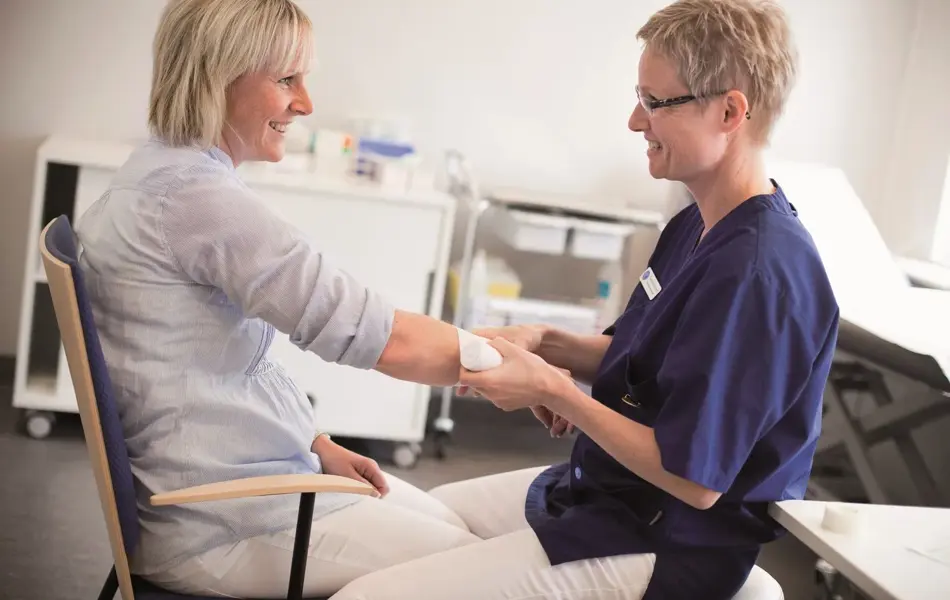 lege som holder i armen til pasient