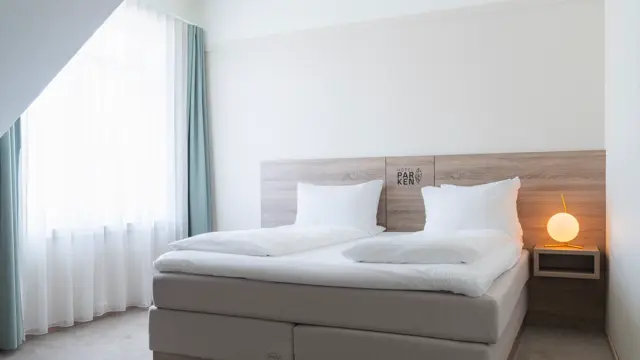 Suite med dobbeltseng, nattbord, teppegulv og stort vindu