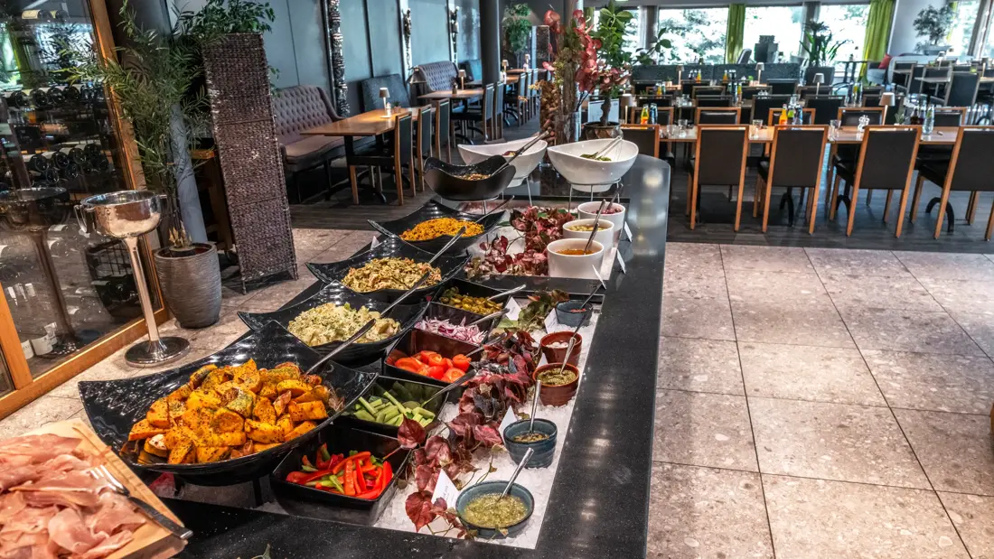Buffet med mange forskjellige retter og oppkuttede grønnsaker i restaurant