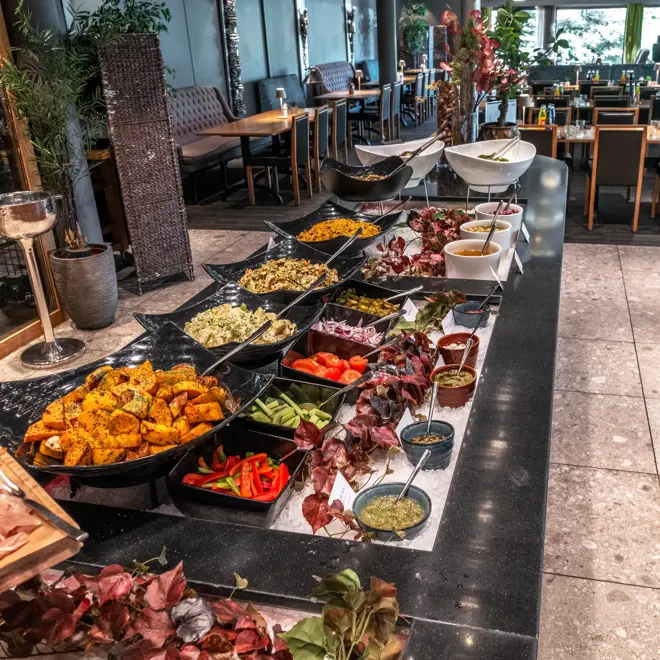Buffet med mange forskjellige retter og oppkuttede grønnsaker i restaurant