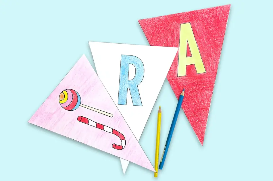 nærbilde av 3 vimpler med R og A og fargeblyanter på blå bakgrunn