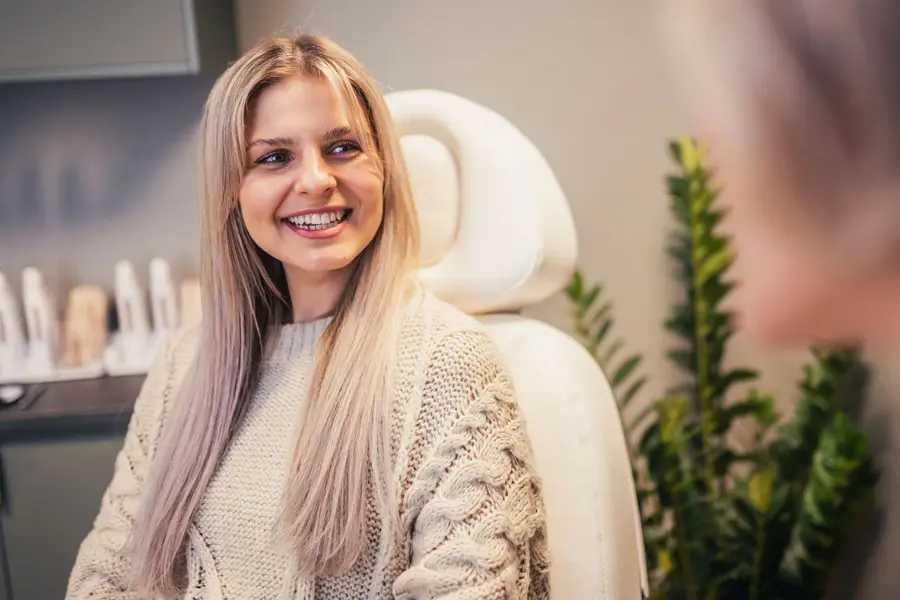 Jente sitter i en behandlingsstol og smiler