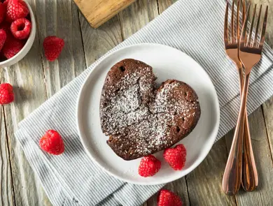Hjerteformet brownie med melisstrøssel med bringebær rundt