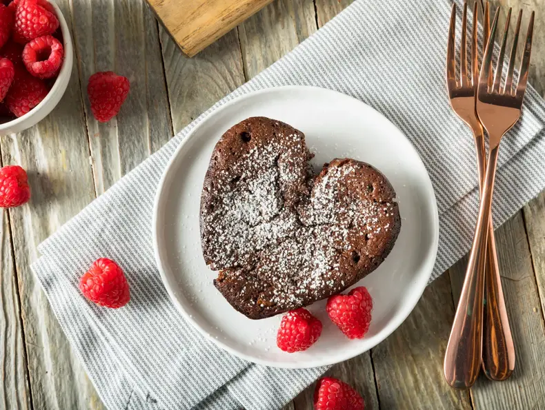 Hjerteformet brownie med melisstrøssel med bringebær rundt