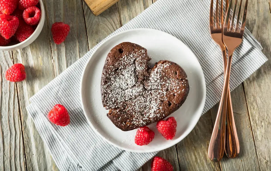 Hjerteformet brownie med melisstrøssel med bringebær rundt