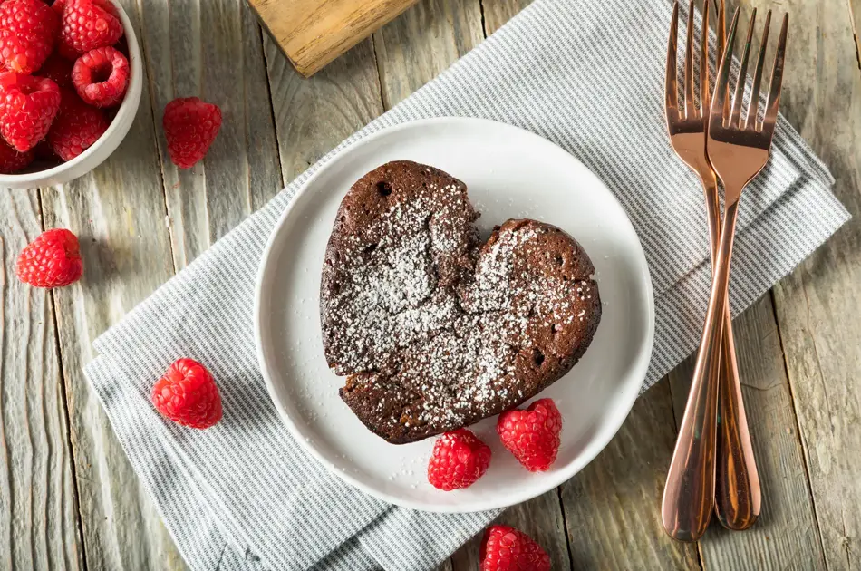 Hjerteformet brownie med melisstrøssel med bringebær rundt