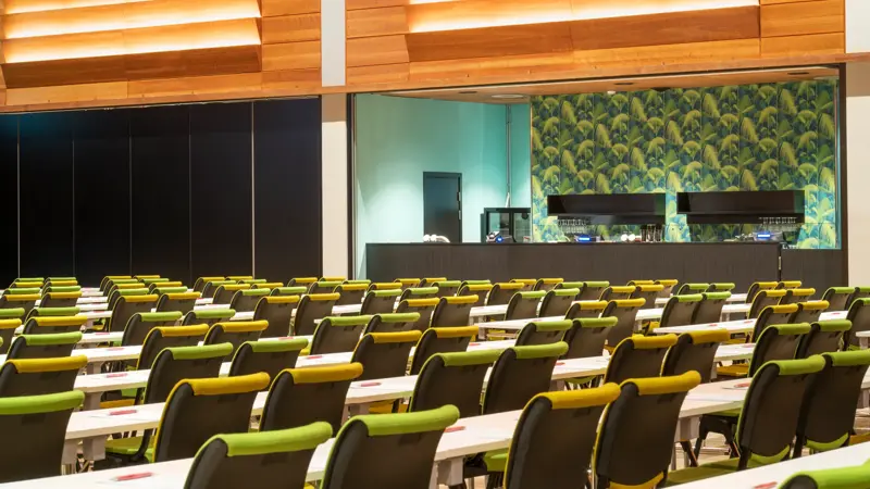 Norgesalen konferanse med parkettgulv i klasseromsoppsett med gule og grønne stoler på Thon Hotel Arena i Lillestrøm