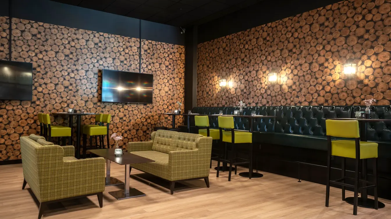 Svart spisesofa, salongbord, parkettgulv, gule barstoler, sittegruppe med sofa, tapetvegg, TV