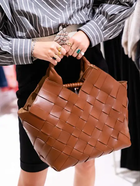 Nærbilde av en brun fletteveske i skinn