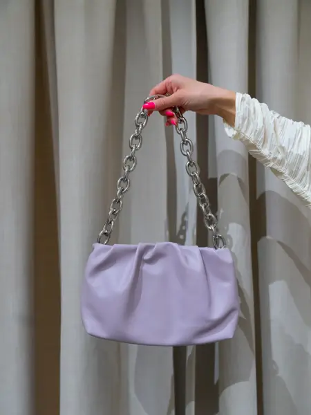 Nina Sandbech på H&M i hvit genser, sort bukse og lilla veske