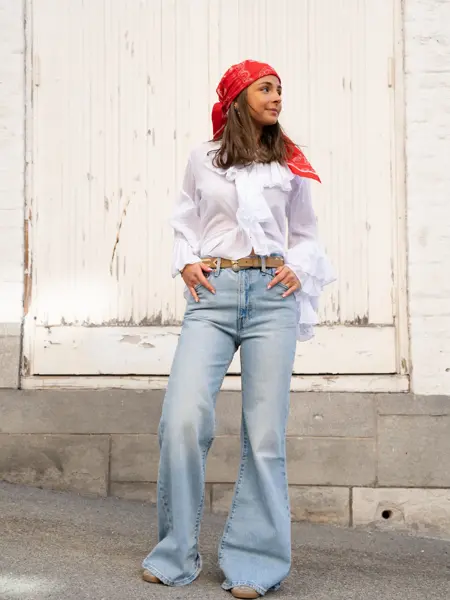 Jente med rødt hårtørkle, hvit skjorte og jeans