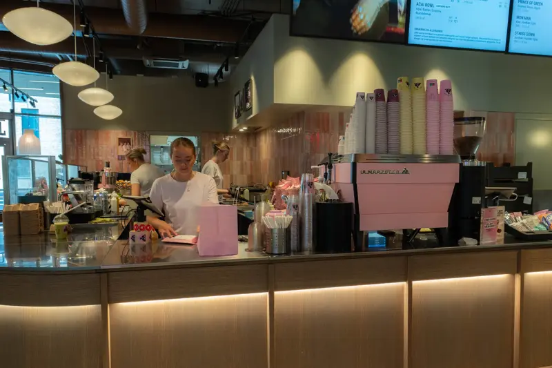 Person som jobber på Joe & Juice bak en disk