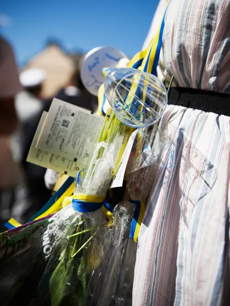 Glass og blomster rundt halsen til en student