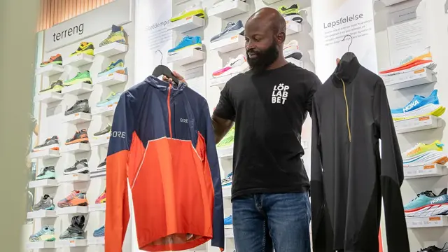 Mann som viser frem bekledning for løping og trening