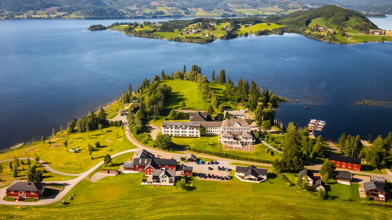 Oversiktsbilde av hotellet sett ovenfra med grønt gress og øylandskap i bakgrunnen