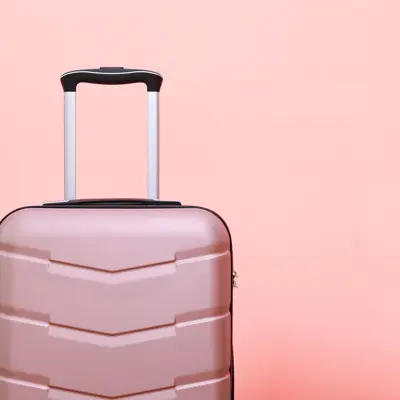 Rosa koffert foran rosa bakgrunn