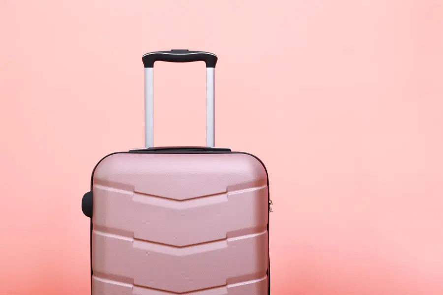 Rosa koffert foran rosa bakgrunn