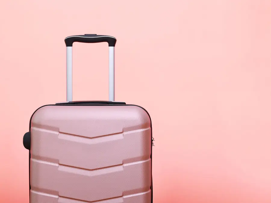 Rosa koffert foran rosa bakgrunn