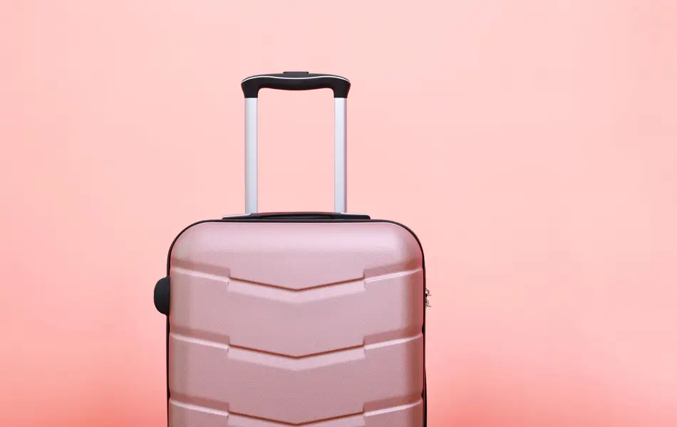 Rosa koffert foran rosa bakgrunn