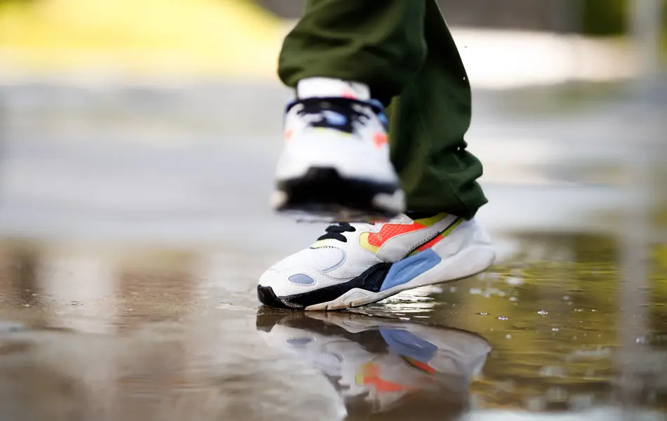 Nærbilde av retro sneakers som hopper i vanndam