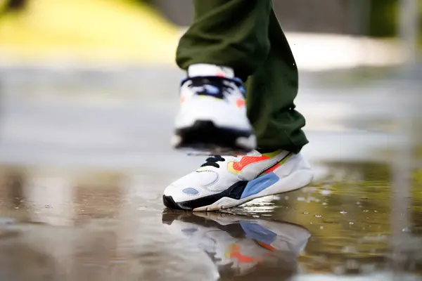 Nærbilde av retro sneakers som hopper i vanndam