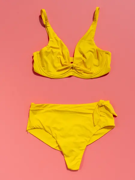 Gul bikini på rosa bakgrunn