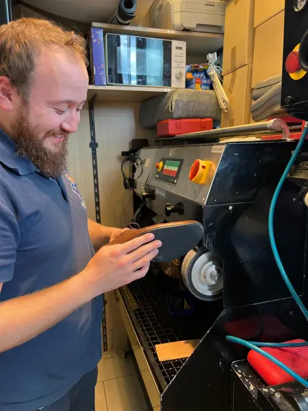 Mann som pusser sålen på en sko