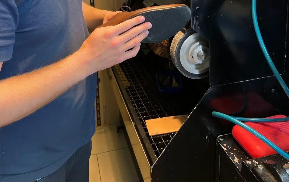 Mann som pusser sålen på en sko