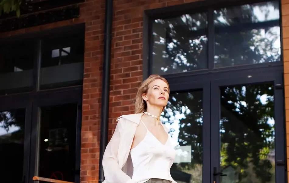 dame med lys topp, frakk og grønn cargobukse