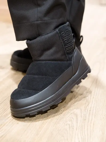 Nærbilde av ben med sorte Uggs