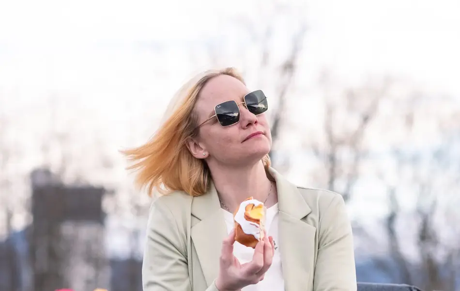 Kvinne som nyter en solskinnsbolle ute