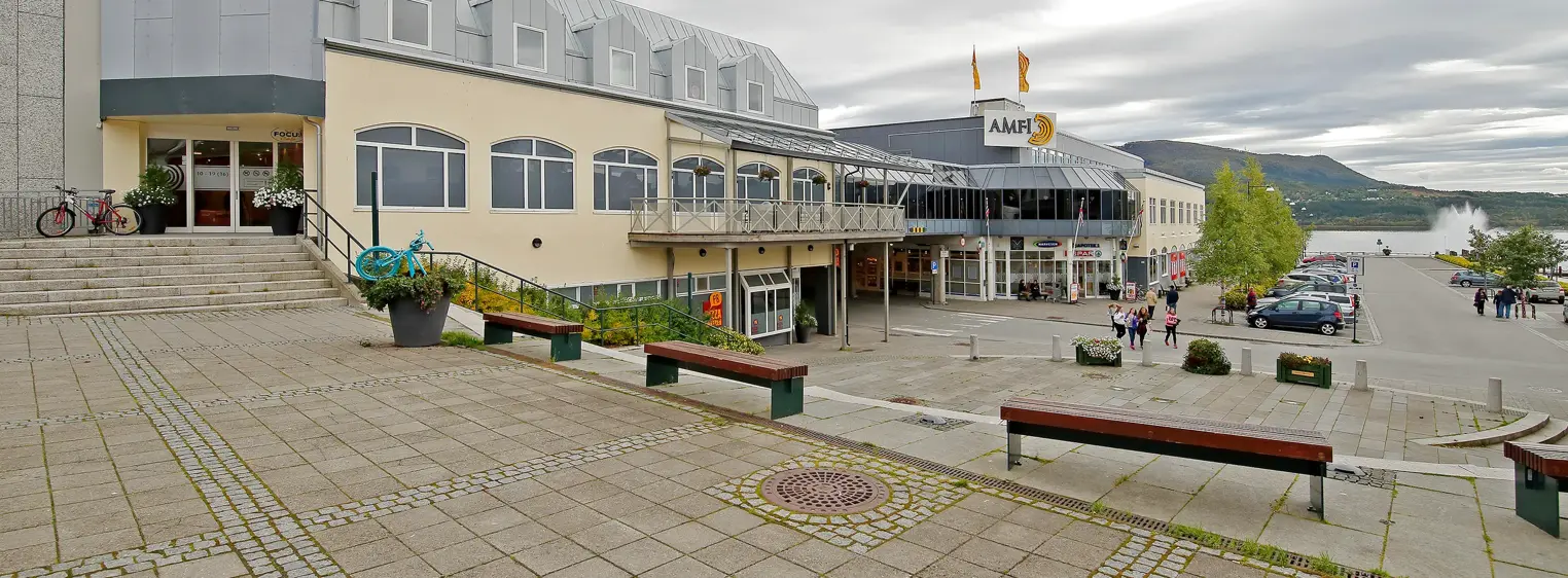 Fasadebilde av AMFI Fauske med benker og inngangsparti