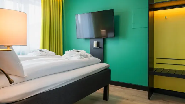 Seng på suite med TV på Thon Hotel Europa i Oslo sentrum rett ved Slottsparken
