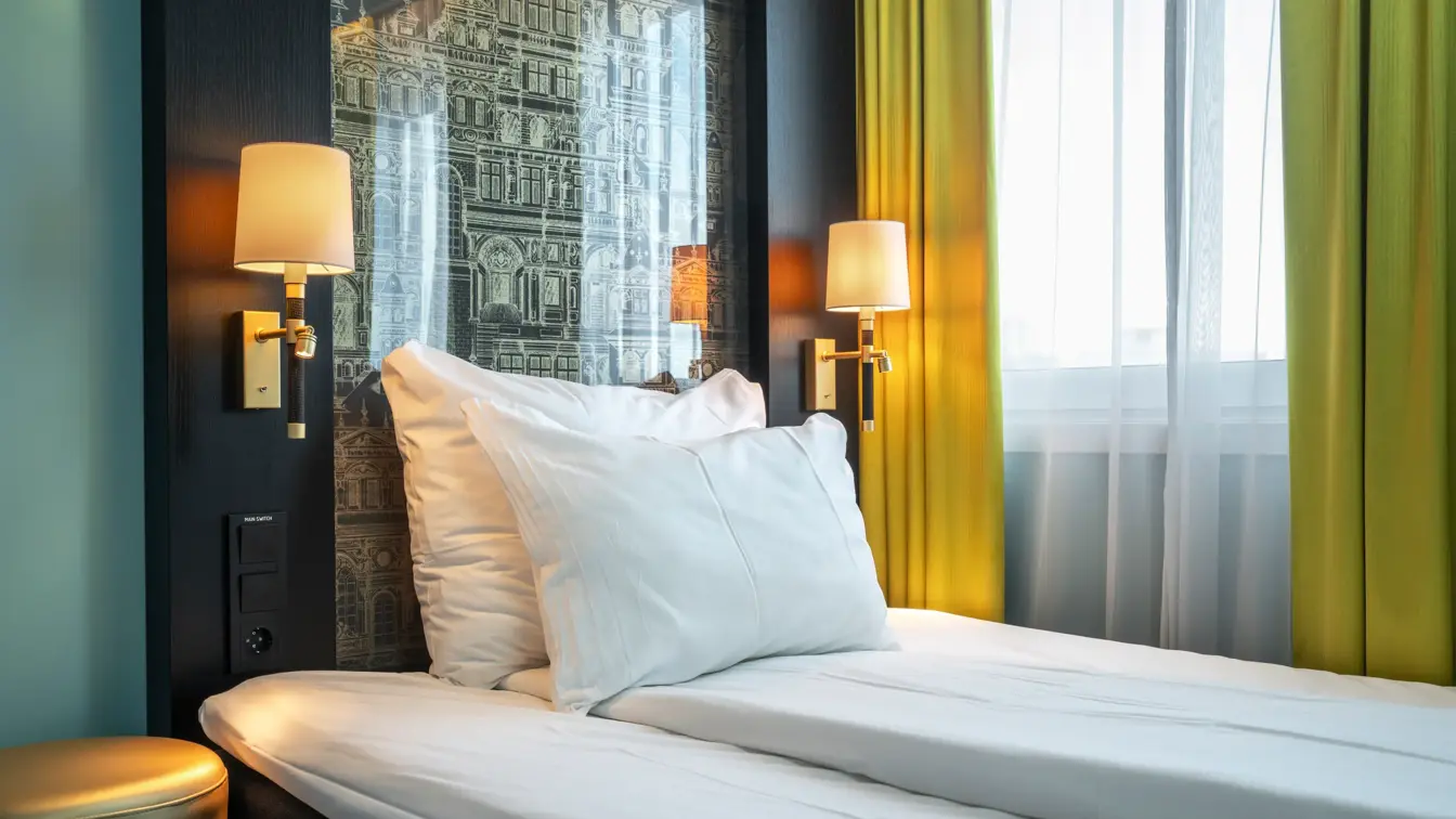 Enkeltrom med enkeltseng, gule gardiner, tente sengelamper.