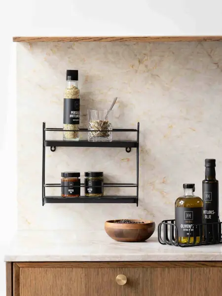 Kjøkkenbenk med oljer, boller og en hylle på veggen.