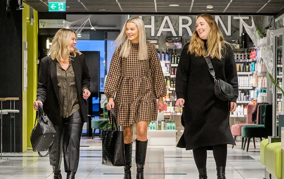 tre damer går i moteriktige klær og tilbehør i gangene til amfi roseby