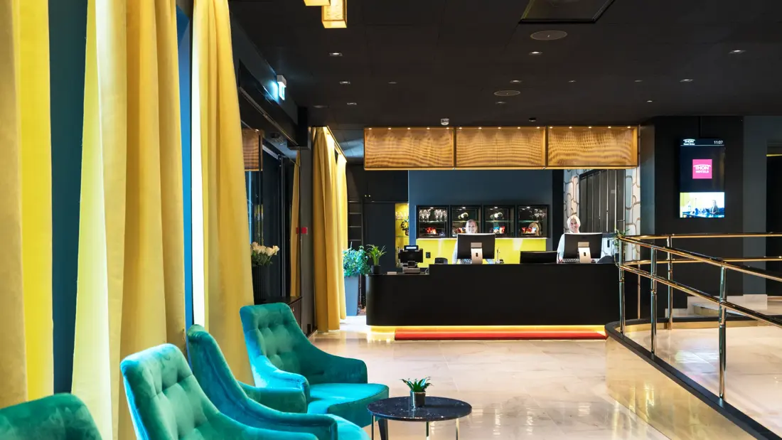 Resepsjon med sittegruppe og smilende resepsjonister på Thon Hotel Orion i Bergen sentrum