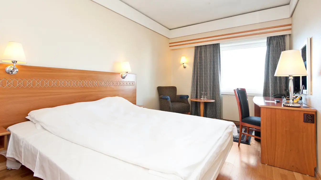 Dobbeltseng og skrivebord i rom på Thon Hotel Saga i Haugesund