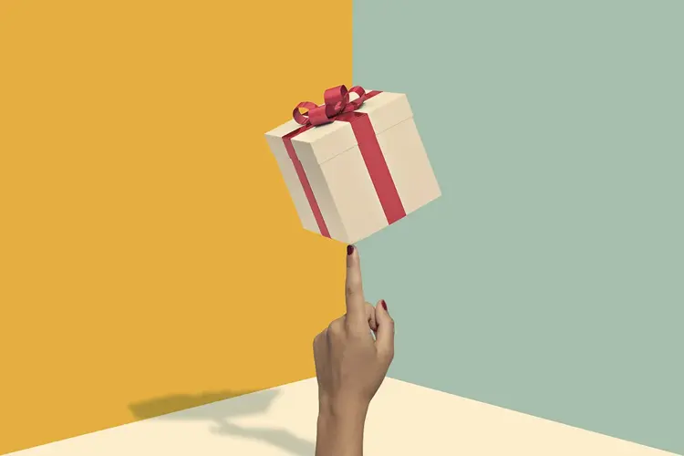 Illustrasjon av firekantet gaveboks med rød sløyfe som balanserer på en finger