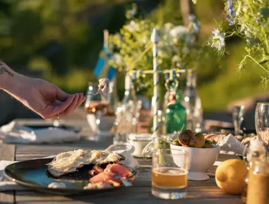 En mann plukker opp et stykke sild fra en tallerken