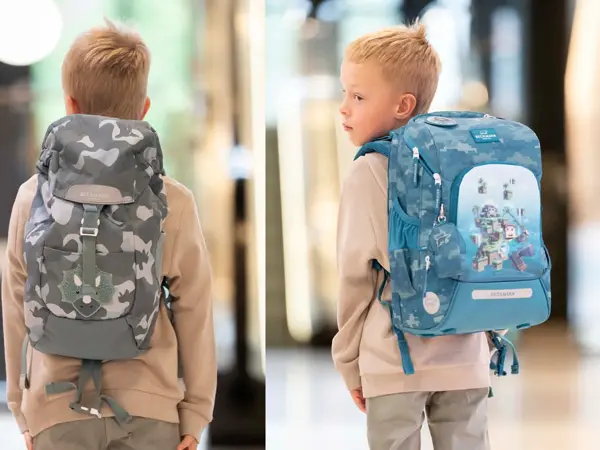gutt med ryggen til kamera med beige genser og grå spettet skolesekk. Gutt ser til siden og har rygg mot kamera og blå skolsesekk