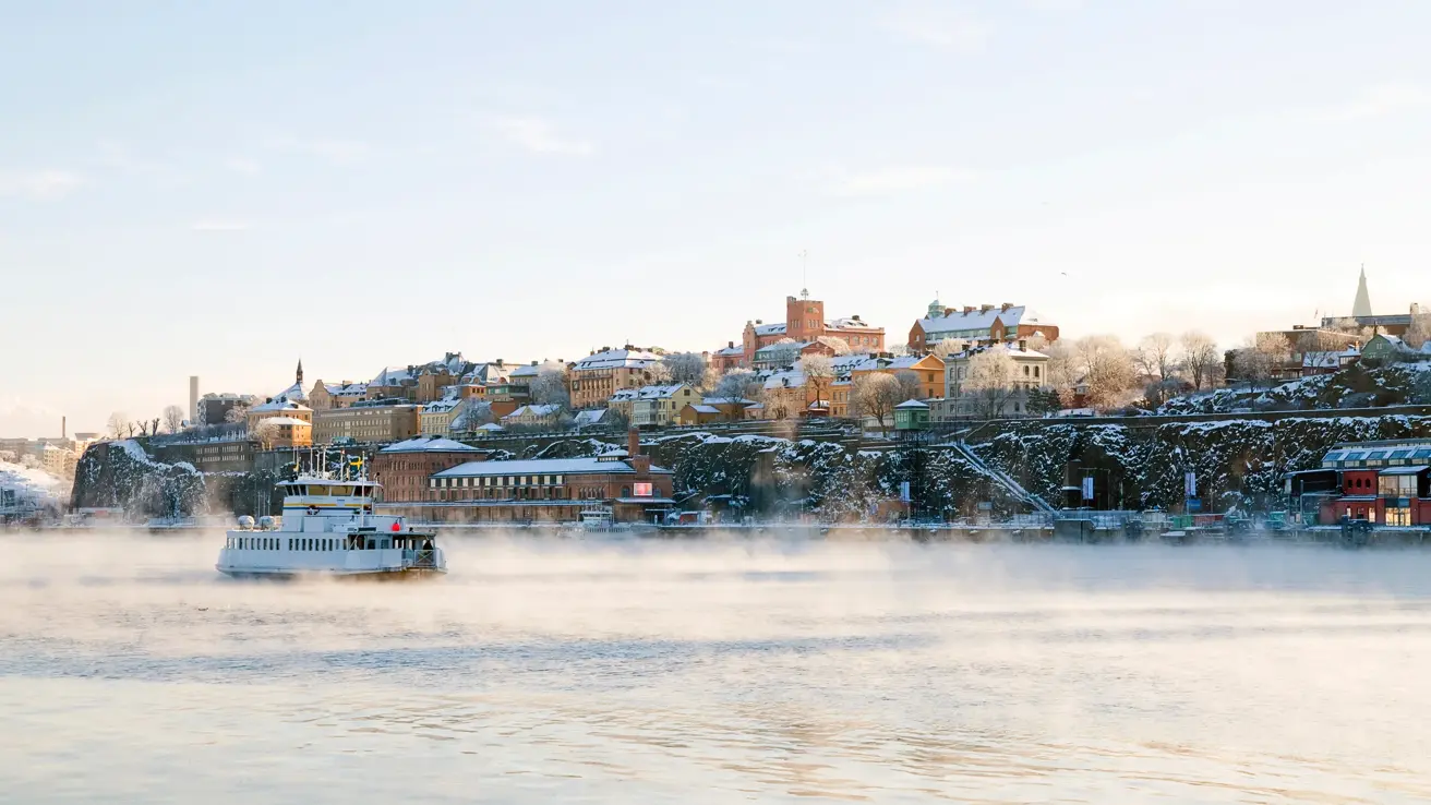 Stockholm i vinterdrakt. ferje på sjøen.