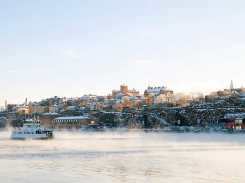 Stockholm i vinterdrakt. ferje på sjøen.