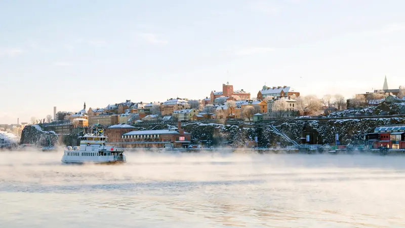 Stockholm i vinterdrakt. ferje på sjøen.