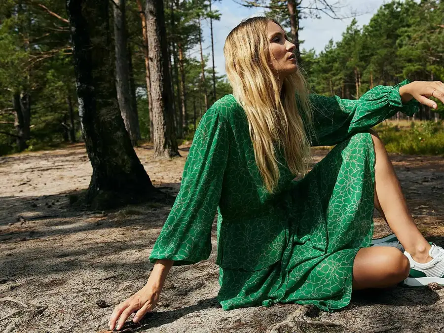 dame som poserer i grønn kjole og sko i hvit og grønt