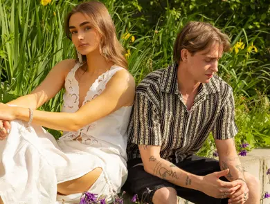 Mann og dame som sitter med grønne planter bak seg